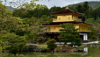 View of Kinkakuji from the front with trees framing the picture.