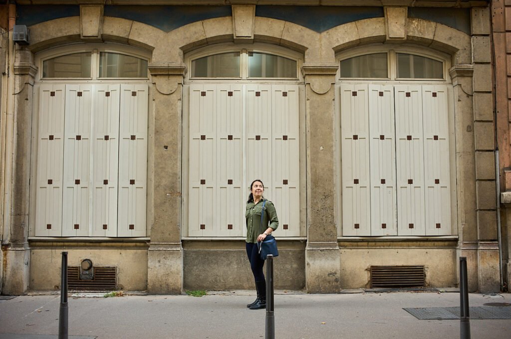 woman standing in front of 3 symmetrical windows. 