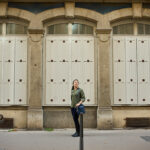 woman standing in front of 3 symmetrical windows in lyon, france