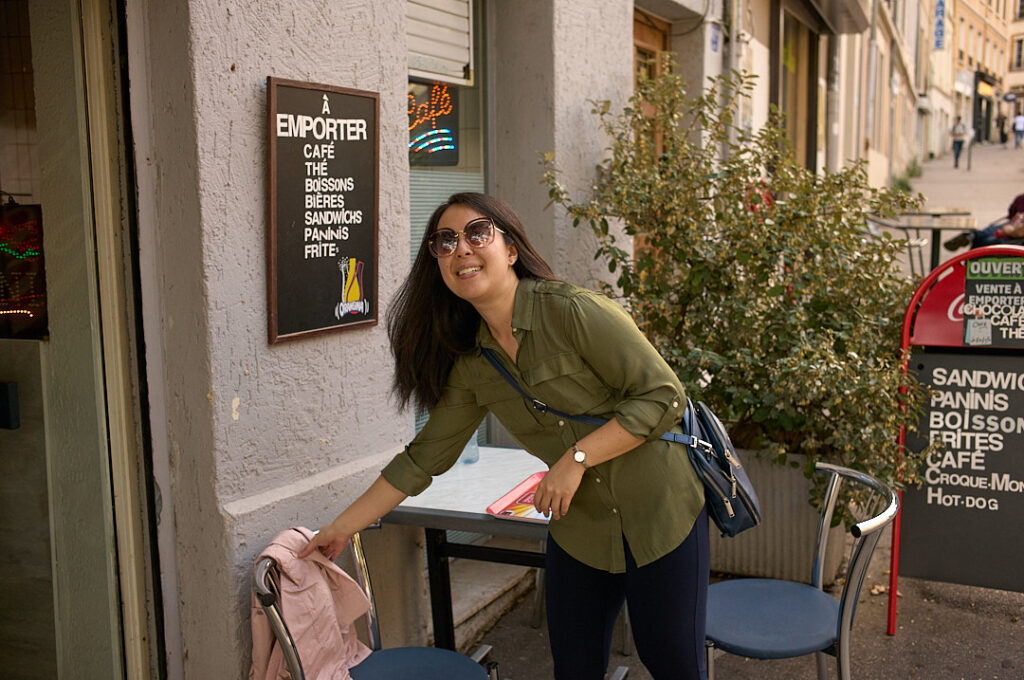 woman putting down coat and taking a seat a cafe 