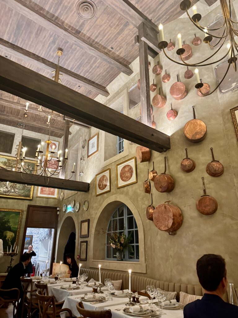 inside a restaurant with copper pots hanging on the wall